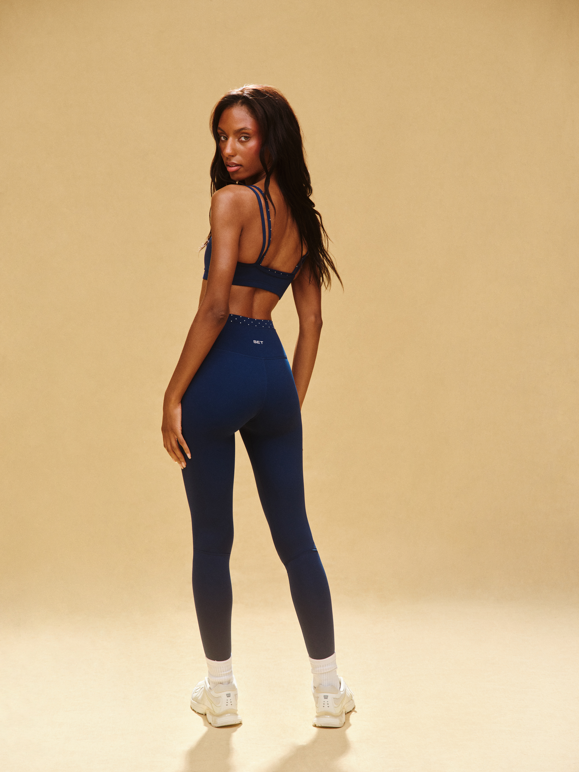 Woman wearing a blue athletic outfit on a beige background