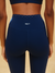 Navy blue leggings with a visible brand logo on a beige background
