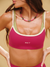 Woman wearing a pink sports bra with 'SET' branding on a beige background