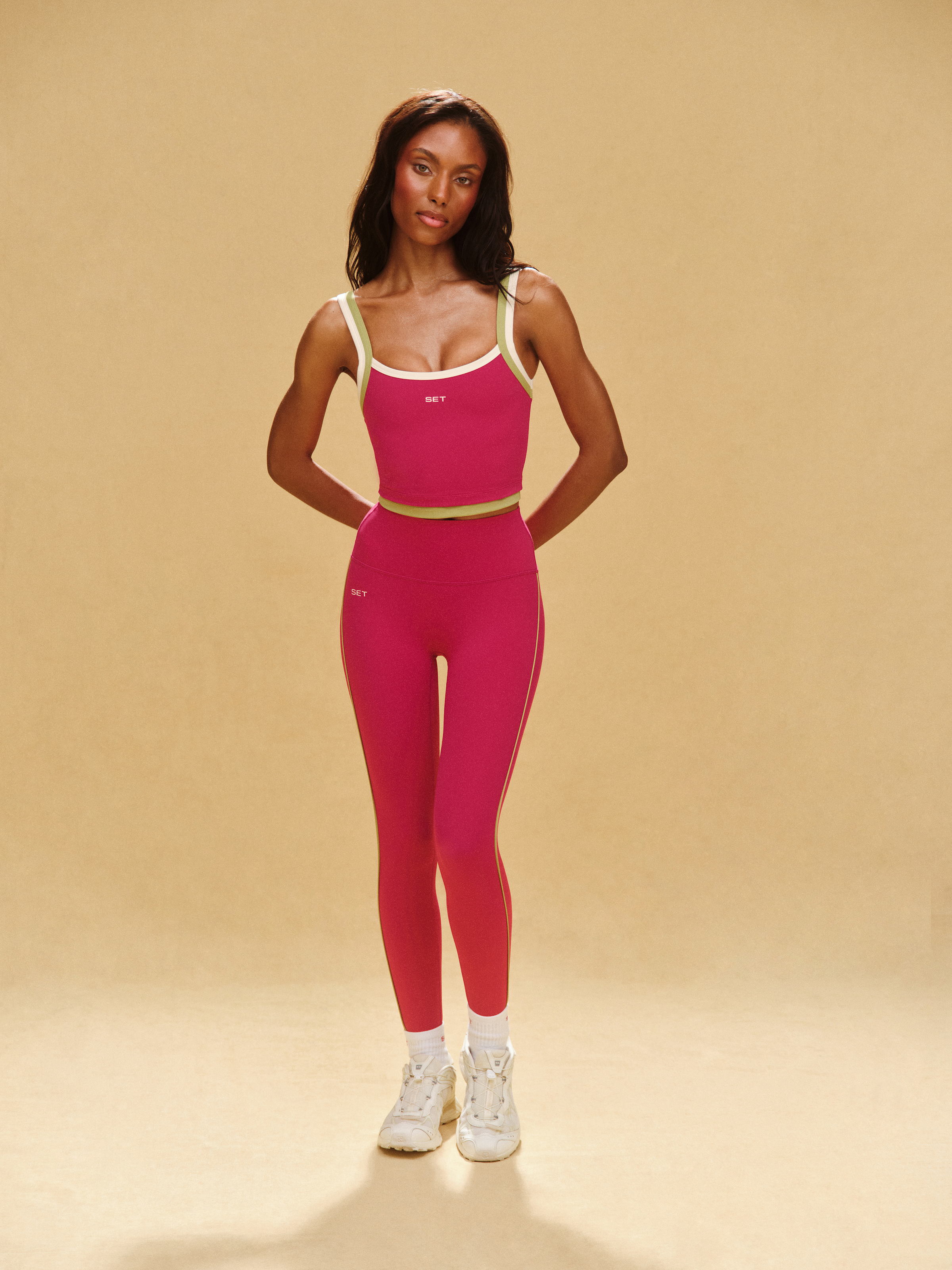 Woman wearing a pink athletic outfit on a beige background