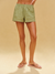 Person wearing green shorts on a beige background