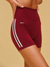 Maroon athletic shorts with white stripes and 'SET' logo on a beige background <model-info>Logan wears a size XS and is 5’9½”, 24” waist, 32B bust.</model-info>