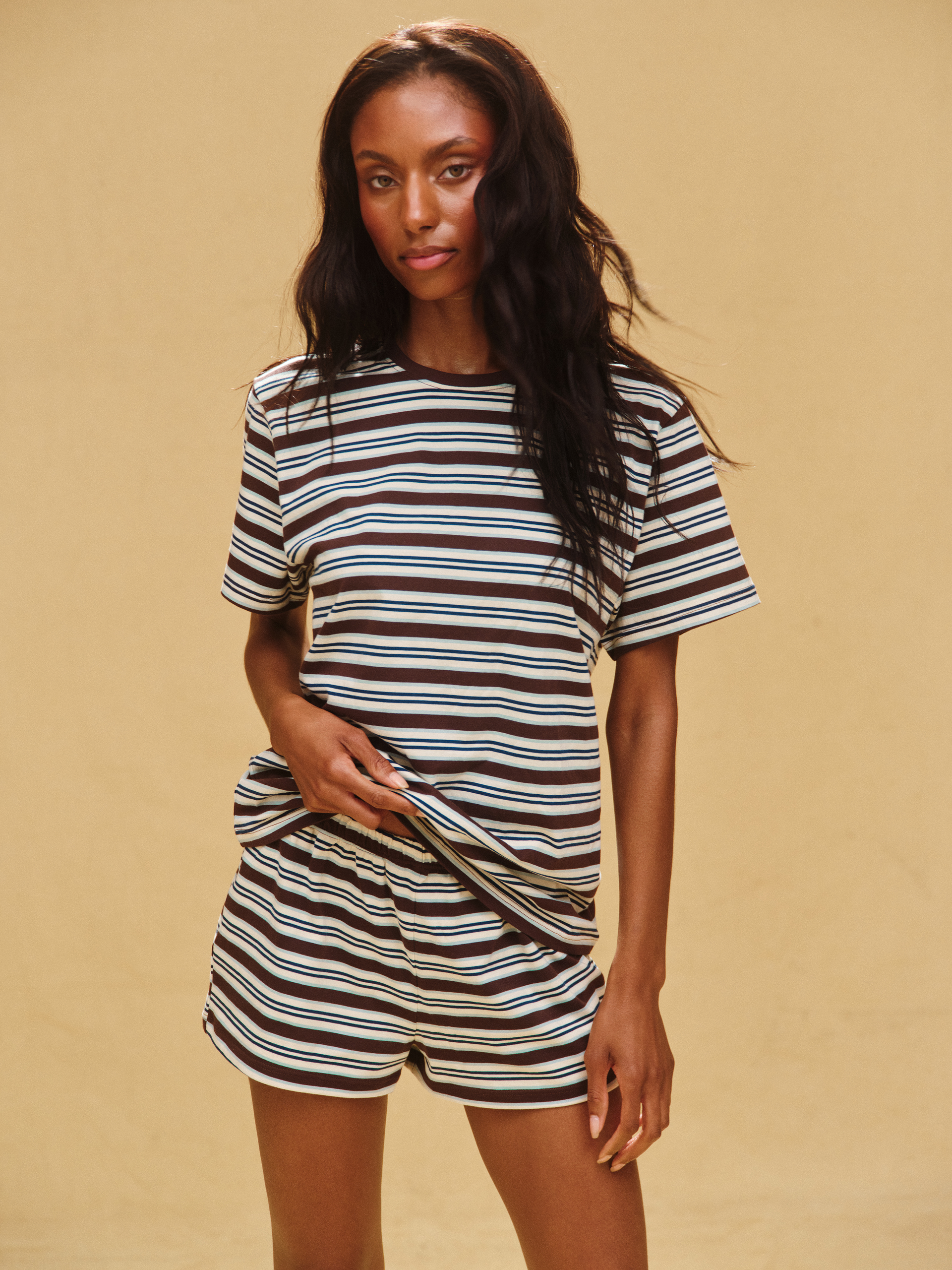Woman wearing a striped outfit on a beige background <model-info>Sydney wears a size XS and is 5’9, 24½” waist, 32B bust.</model-info>