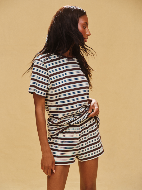 Woman wearing a striped outfit on a beige background