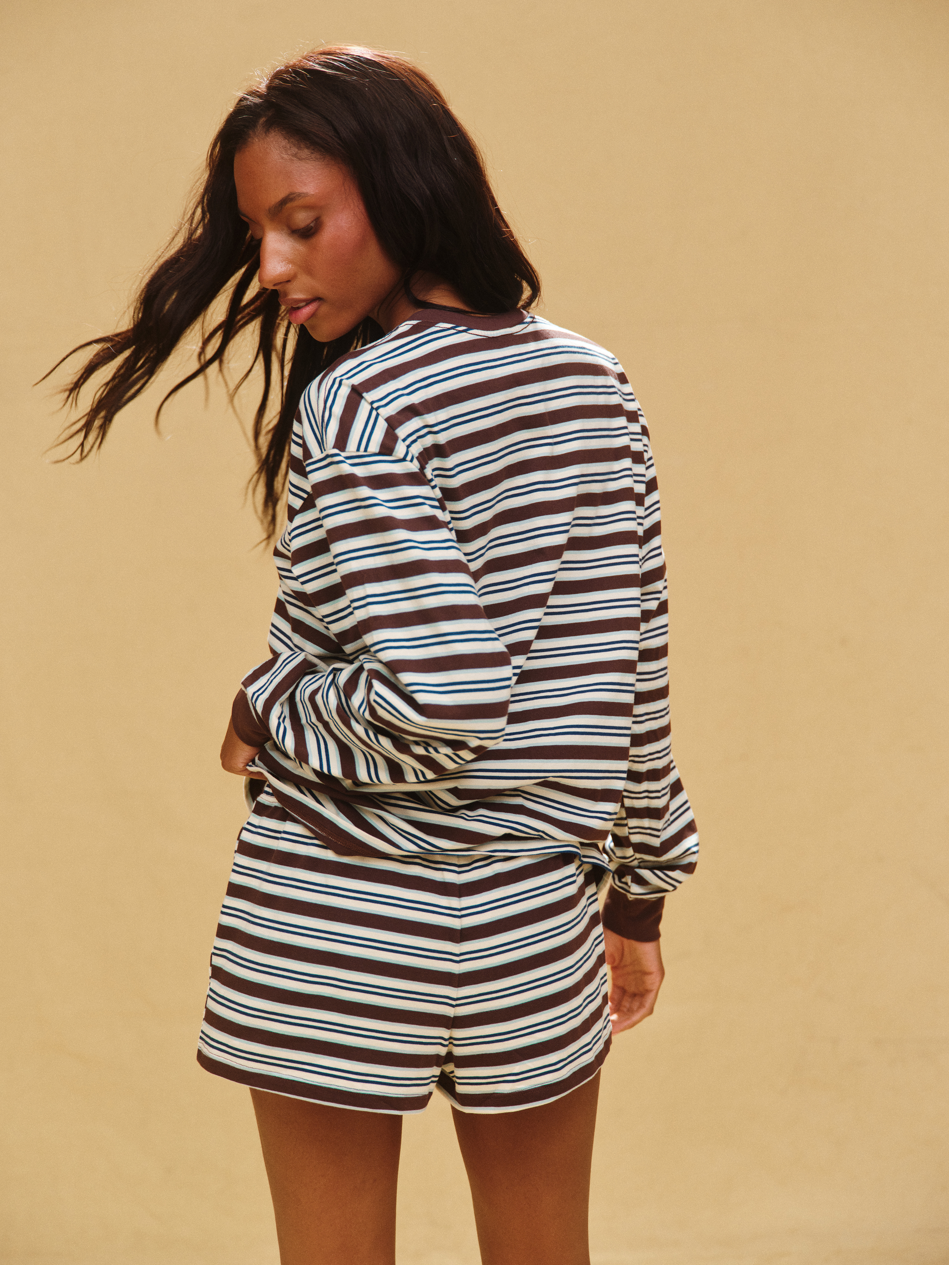 Woman wearing a striped dress against a beige background