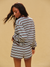 Woman wearing a striped dress against a beige background