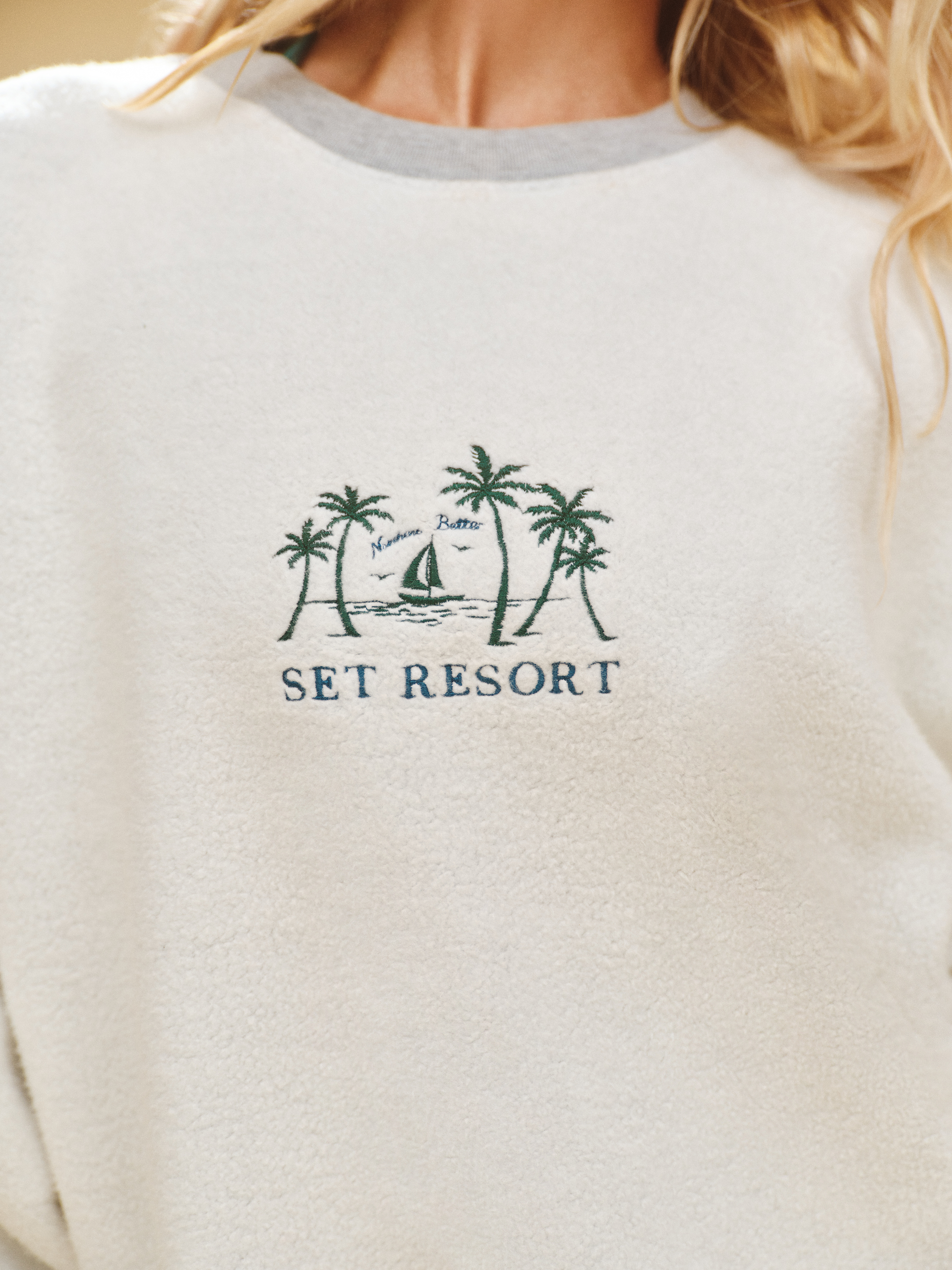 White sweatshirt with palm tree design and 'Set Resort' text on a white background