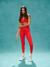 Woman wearing a red athletic outfit on a teal background