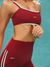 Person wearing a red sports bra and leggings with 'SET' branding against a teal background