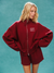 Person wearing a red tracksuit with 'SET' logo on a teal background <model-info>Allie wears a size S and is 5’7½, 25” waist, 32B bust.</model-info> 