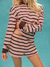 Person wearing a striped outfit with a turquoise background
