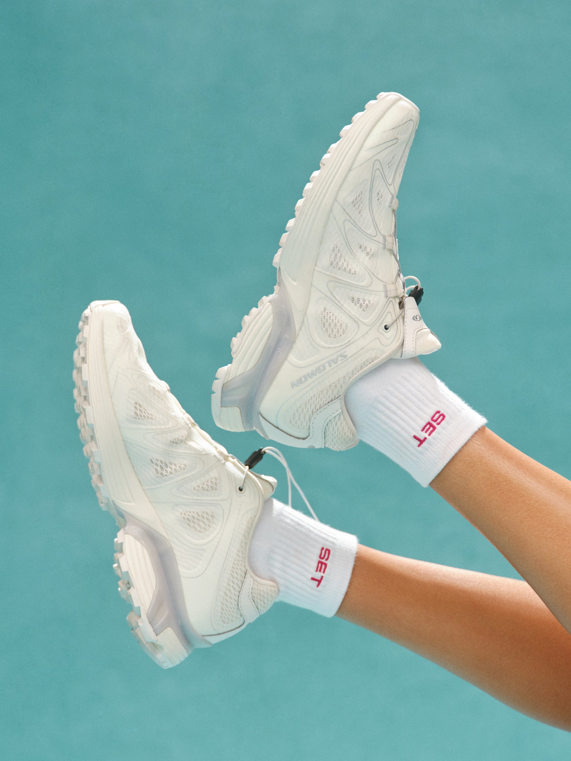 White sneakers and socks with 'SET' branding on a teal background