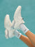 White sneakers and socks against a teal background