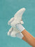 White sneakers being worn against a teal background