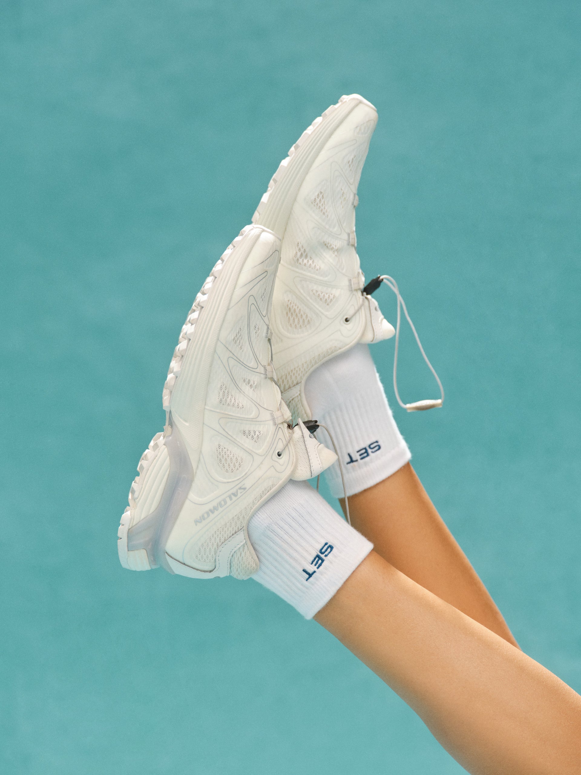 White sneakers with 'SET' branding on a teal background