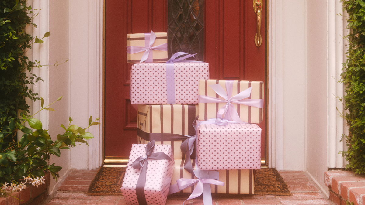 Stack of gift boxes with ribbons in front of a red door.