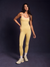 Woman wearing a yellow bodysuit against a dark background <model-info>Jelene wears a size XS and is 5’7”, 23” waist, 32AB bust.</model-info>