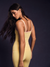 Woman wearing a yellow top and leggings against a dark background