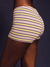 Striped swimsuit with yellow, purple, and black stripes on a dark background  <model-info>Umi wears a size S and is 5’8½”, 23½” waist, 32B bust.</model-info>
