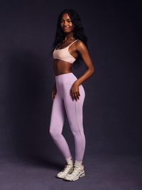 Woman wearing a sports bra and leggings on a dark background 