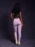 Person wearing light purple leggings on a dark background