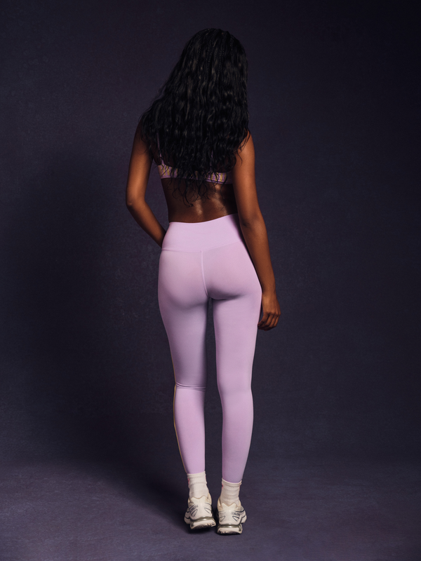 Person wearing light purple leggings on a dark background