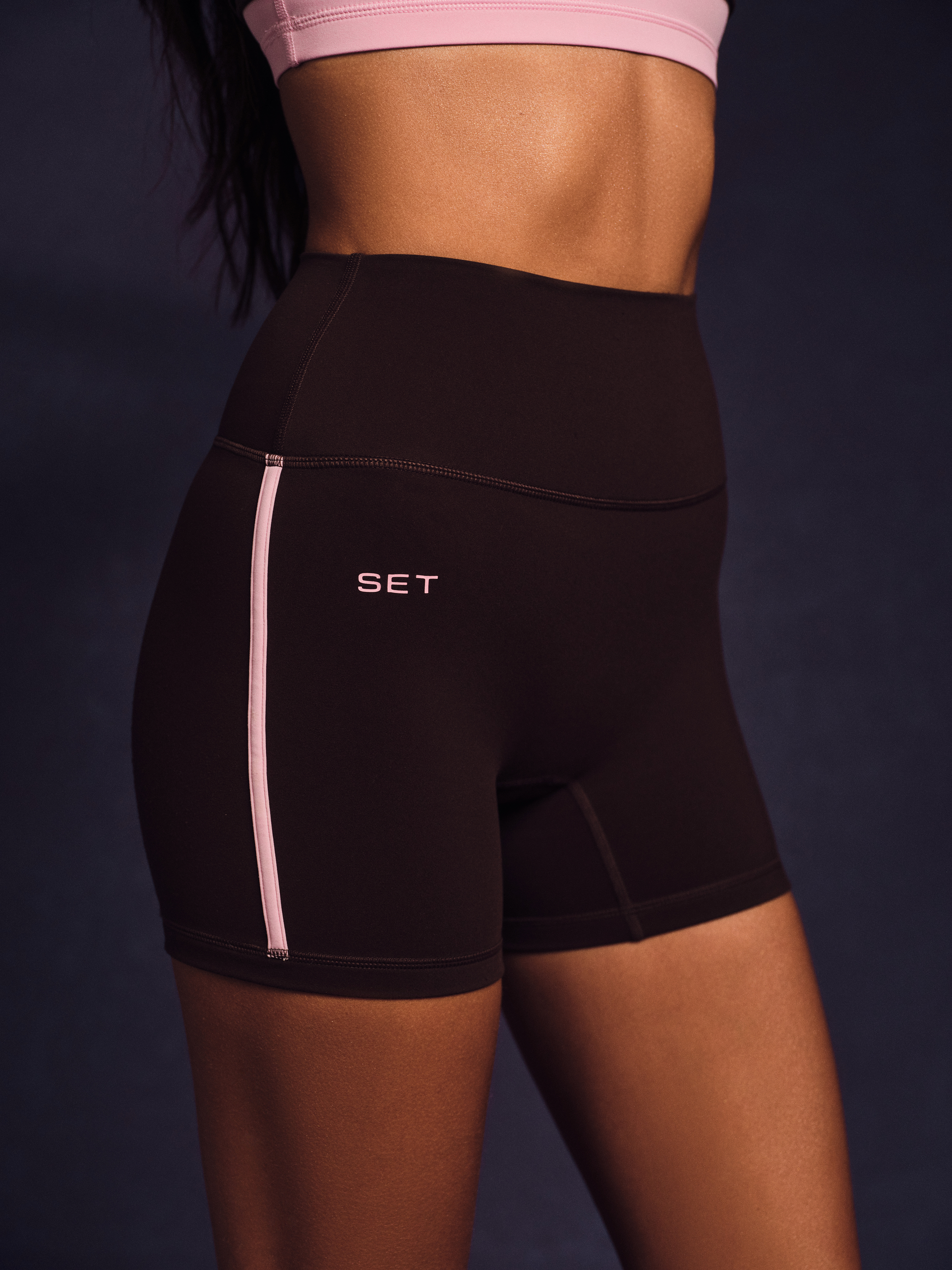 Black athletic shorts with a visible brand logo on a dark background  <model-info>Jelene wears a size XS and is 5’7”, 23” waist, 32AB bust.</model-info>