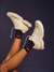 White sneakers and brown socks with white polka dots on a dark background