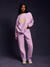 Person wearing a light purple tracksuit with 'SET' text on a dark background