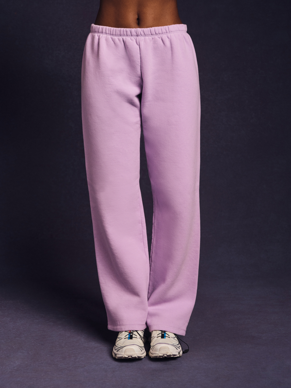 Person wearing light purple sweatpants on a dark background