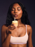 Woman blowing out a candle on a cupcake against a dark background <model-info>Umi wears a size XS and is 5’8½”, 23½” waist, 32B bust.</model-info>