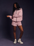 Person wearing a pink and white striped outfit on a dark background
