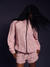 Person wearing a pink striped outfit on a dark background