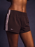 Brown athletic shorts with white stripes and 'SET' logo on a dark background <model-info>Umi wears a size S and is 5’8½”, 23½” waist, 32B bust.</model-info>