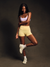 Woman in athletic wear posing against a dark background