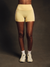 Person wearing beige athletic shorts and white sneakers on a dark background