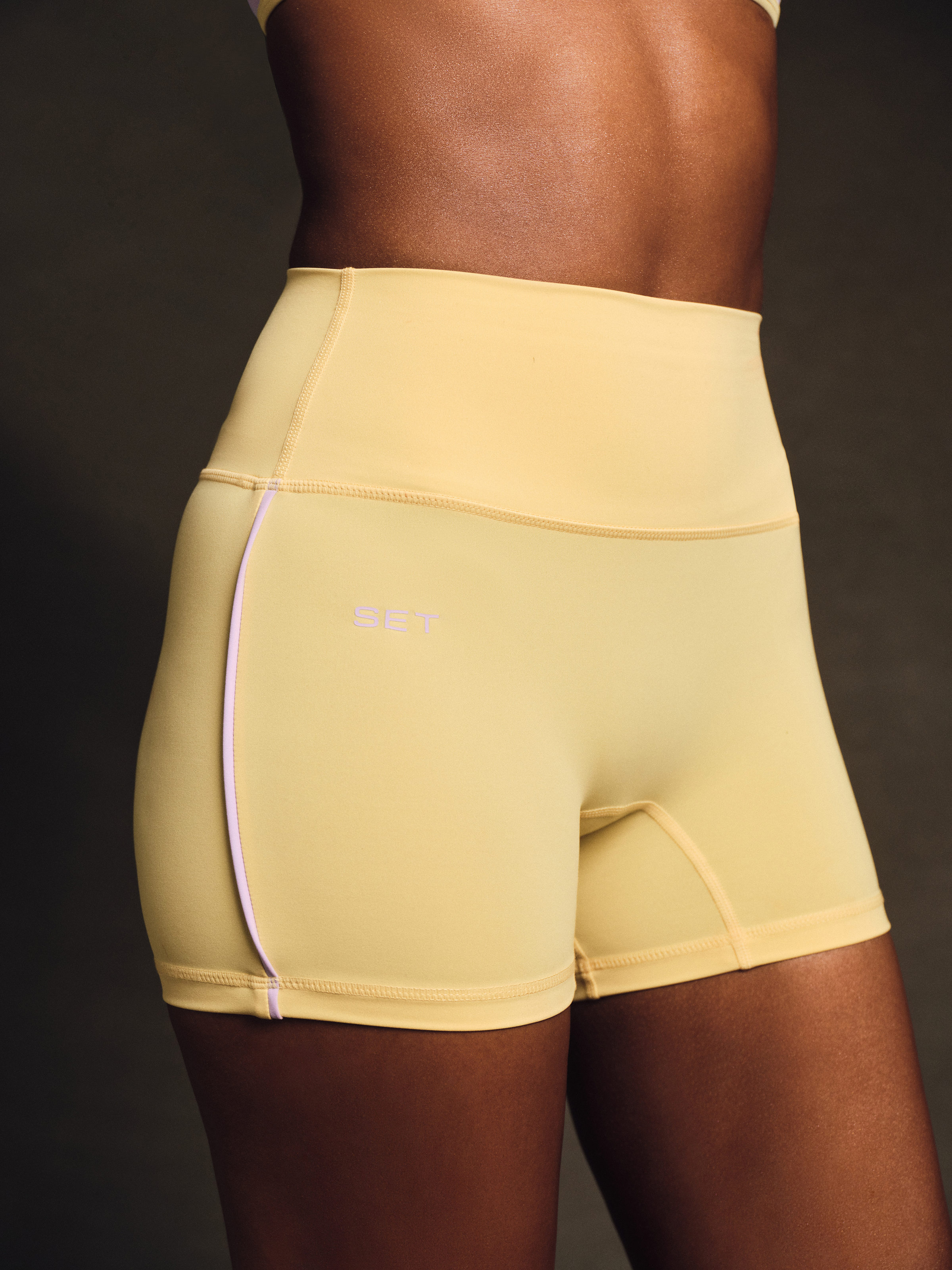 Beige athletic shorts with a brand logo on a dark background 