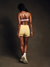 Person wearing a sports bra and shorts on a dark background
