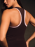 Woman wearing a dark brown tank top with white trim on a dark background