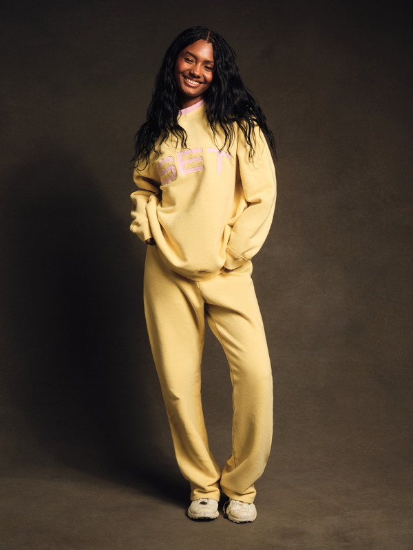 Model wearing yellow SET sweatshirt and matching sweatpants with relaxed fit 