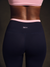 Person wearing black leggings with pink waistband and 'SET' logo on a dark background