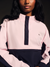 Person wearing a pink and navy outfit with a brand logo on a dark background