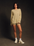 Woman wearing a striped long-sleeve top and shorts on a dark background