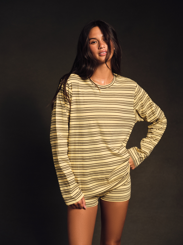 Person wearing a yellow and black striped shirt against a dark background 