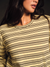 Close-up of a person wearing a yellow and black striped shirt against a dark background