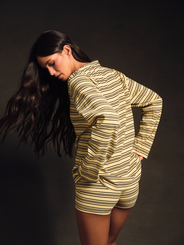 Woman wearing a striped outfit against a dark background