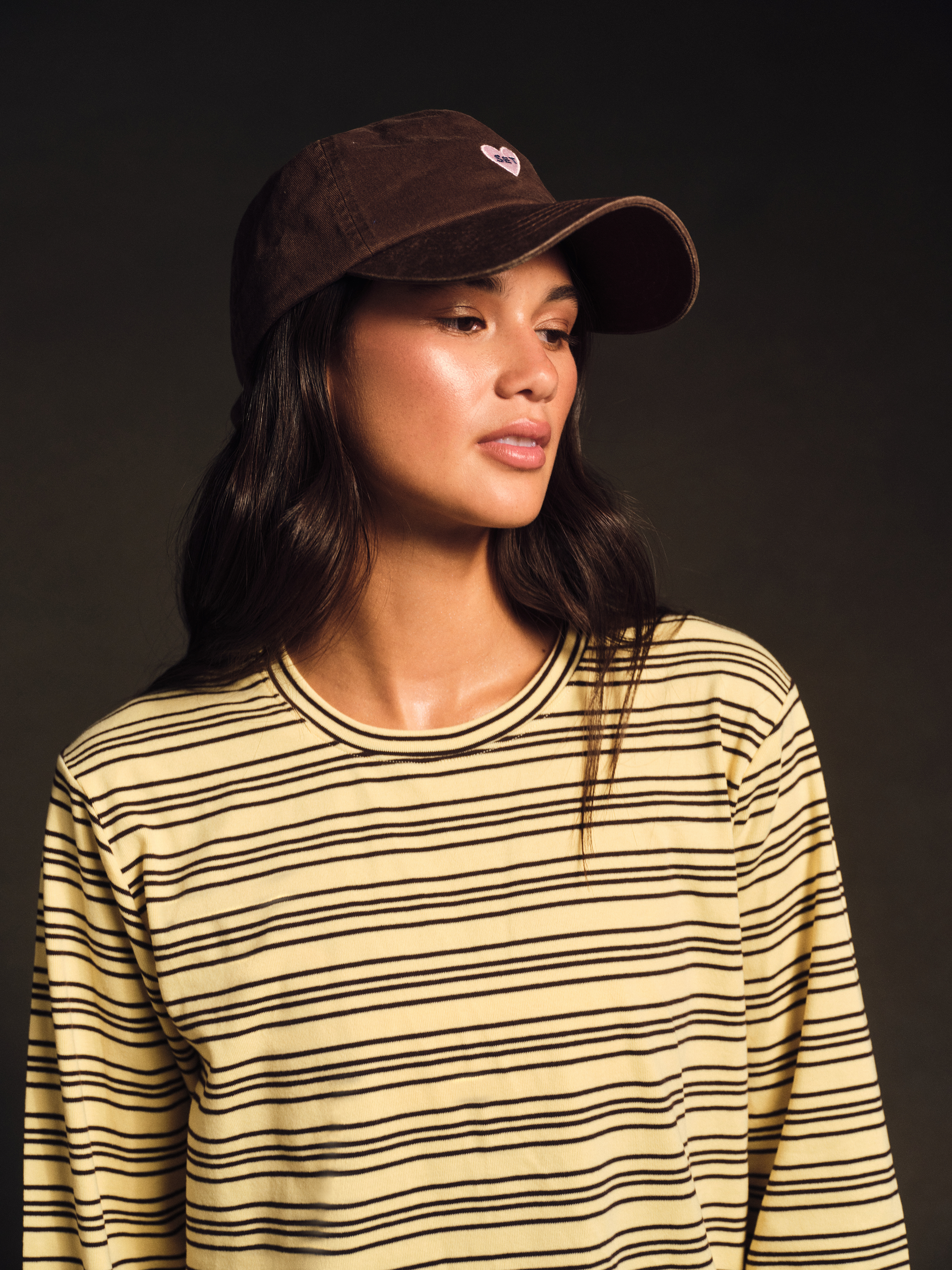 Person wearing yellow striped shirt and brown hat