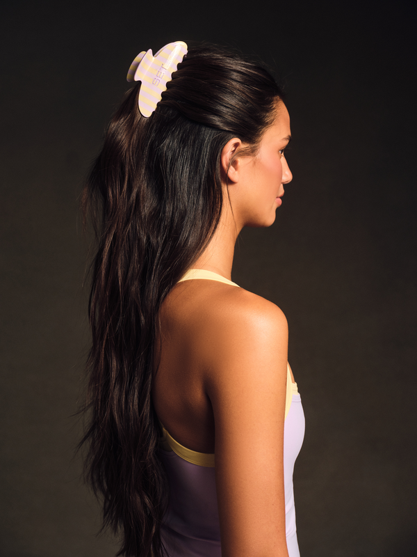 Woman with a butterfly hair clip on a dark background
