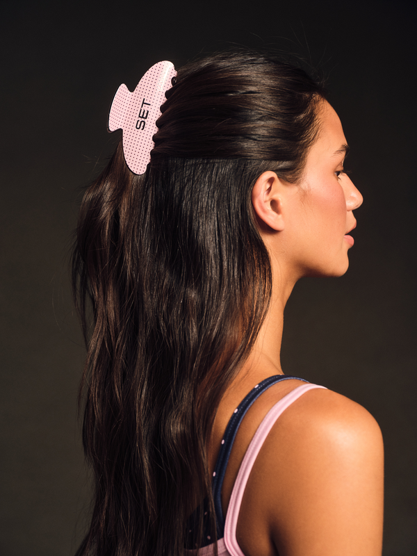 Pink SET claw clip in long dark hair, side view