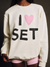 Person wearing a white sweatshirt with 'I ❤️ SET' text design.